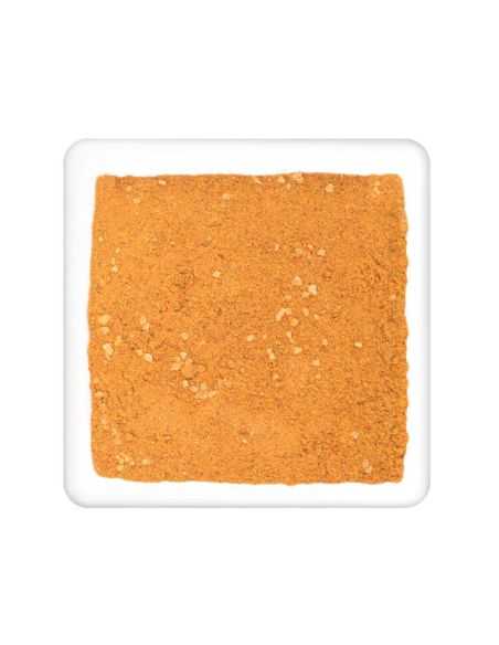 Quadratischer Teller mit fein gemahlenem, orangefarbenem Currypulver mit hellen Stückchen Quadratischer Teller mit fein gemahlenem, orangefarbenem Currypulver mit hellen Stückchen