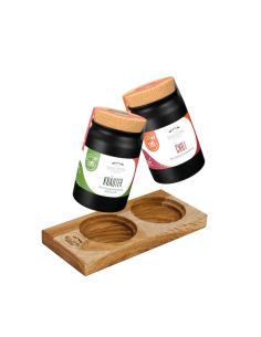 Zwei schwarze Keramiktöpfchen mit den Aufschriften „Chili“ und „Kräuter“ über einem zweiteiligen Tischset