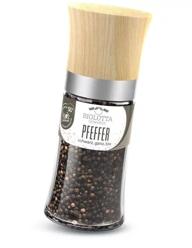 Gewürzmühle mit schwarzen Pfefferkörnern und grünem Etikett.