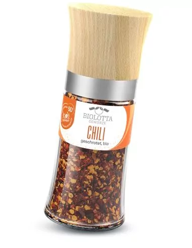 Mühle mit roten Chiliflocken und leuchtend orangem Etikett.