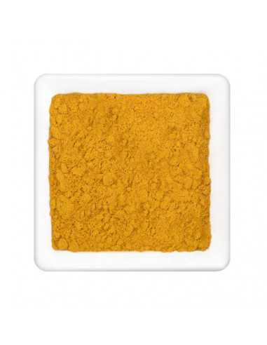 Quadratischer weißer Teller mit gelbem Currypulver.