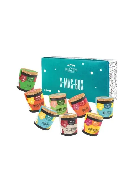 Acht bunte Bio-Pappdosen vor türkisfarbener Geschenkbox mit der Aufschrift „X-MAS-BOX“.