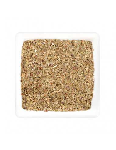 Weißer quadratischer Teller mit getrockneten, grob gerebelten Basilikumblättern in hellgrüner bis bräunlicher Farbe.