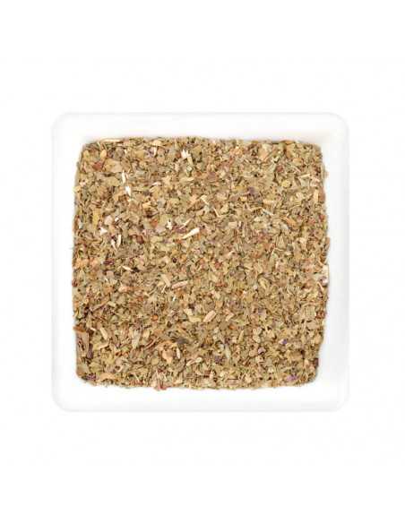 Weißer quadratischer Teller mit getrockneten, grob gerebelten Basilikumblättern in hellgrüner bis bräunlicher Farbe.