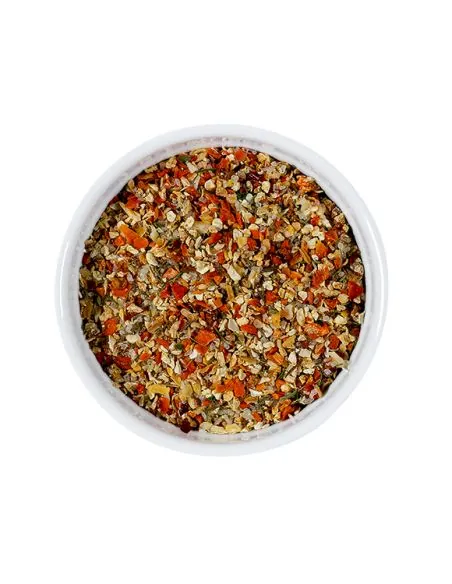Bunte Mischung aus Kräutern und Salz mit roten und gelben Stücken in weißer Schale.