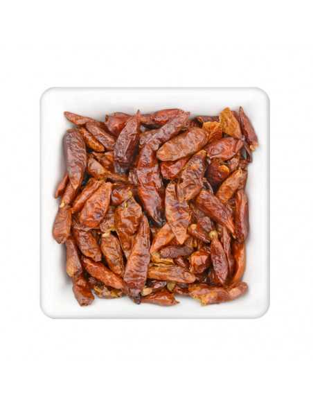 Quadratische, weiße Schale mit kleinen, rotbraunen, getrockneten Chilischoten.