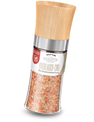Gewürzmühle mit Holzdeckel und roter Bio-Gewürzmischung.