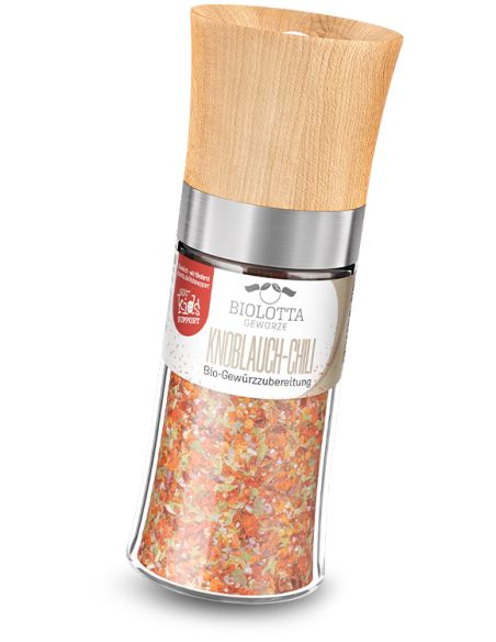 Gewürzmühle mit Holzdeckel und roter Bio-Gewürzmischung.