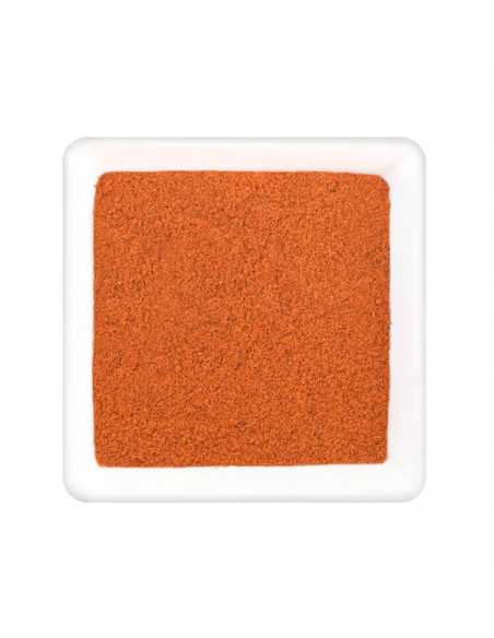 Quadratische weiße Schale gefüllt mit feinem, rotbraunem Paprikapulver.