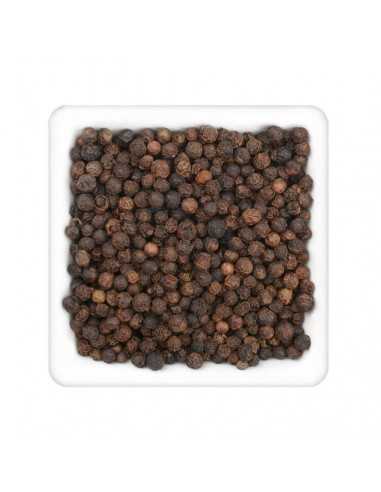 Nahaufnahme vieler ganzer schwarzer Pfefferkörner in einer weißen quadratischen Schale.