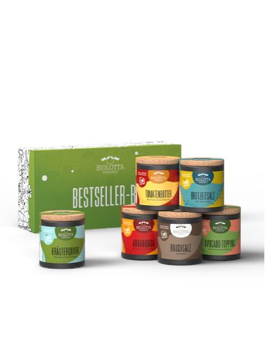 Grüne Geschenkbox mit der Aufschrift „Bestseller-Box“, davor sechs bunte Bio-Pappdosen mit verschiedenfarbigen Etiketten.
