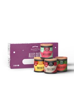Vier bunte Bio-Pappdosen vor lilafarbener Geschenkbox mit dem Schriftzug „Alles Gute!“ und einem Namensfeld