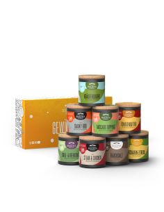 Acht bunte Bio-Pappdosen vor einer orangefarbenen Geschenkbox mit der Aufschrift „Gewürz-Box“