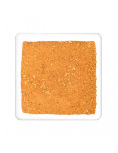 Feines, orange-gelbes Currypulver mit sichtbaren kleinen Stückchen, flach auf weißem Teller verteilt.