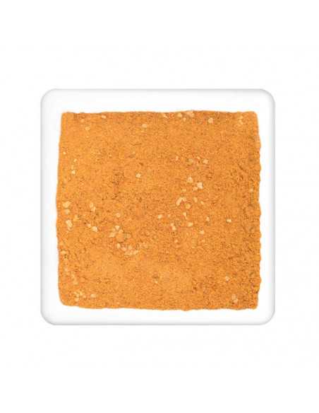 Feines, orange-gelbes Currypulver mit sichtbaren kleinen Stückchen, flach auf weißem Teller verteilt.