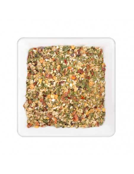 Quadratischer Teller mit bunter, grober Gewürzmischung mit grünen, roten und gelblichen Stücken