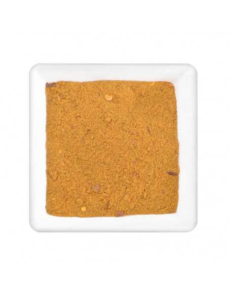 Quadratischer Teller mit feinem, curryfarbenem Pulver mit leichtem Orangestich