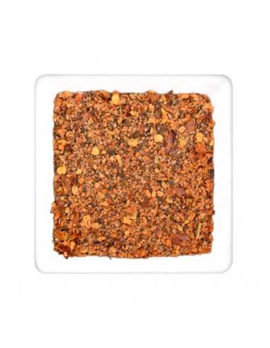 Quadratischer Teller mit grober Gewürzmischung in rötlich-braunen Tönen mit kleinen gelben Stückchen