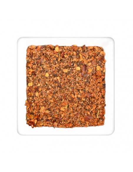 Quadratischer Teller mit grober Gewürzmischung in rötlich-braunen Tönen mit kleinen gelben Stückchen
