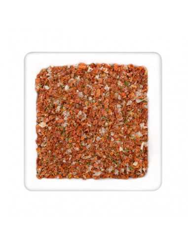 Quadratischer Teller mit grober Gewürzmischung aus roten Tomatenstückchen, Kräutern und Salzkristallen