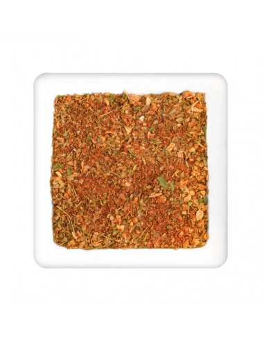 Quadratischer Teller mit grober, rot-grüner Gewürzmischung aus Kräuterstückchen und Paprikapulver