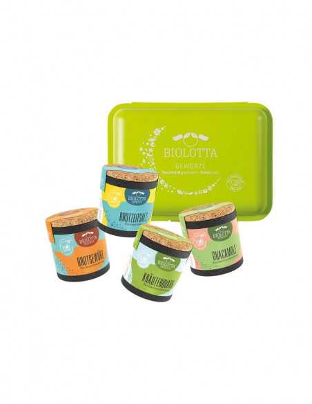 vier bunte Keramiktöpfchen mit Korkdeckel in Grün-, Gelb- und Blautönen stehen vor einer grünen Brotdose mit Biolotta-Logo.