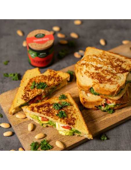 Schwarze Pappdose neben goldbraun gebratenen Sandwiches mit geschmolzenem Käse und Petersilie auf Holzbrett Schwarze Pappdose neben goldbraun gebratenen Sandwiches mit geschmolzenem Käse und Petersilie auf Holzbrett