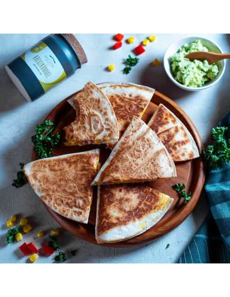 Teller mit aufgeschnittenen Quesadillas, dekoriert mit Gemüse und Kräutern, daneben ein geöffnetes Keramiktöpfchen Kreuzkümmel. Teller mit aufgeschnittenen Quesadillas, dekoriert mit Gemüse und Kräutern, daneben ein geöffnetes Keramiktöpfchen Kreuzkümmel.