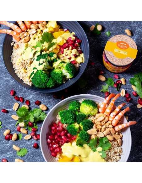 Zwei Bowls mit verschiedenen Zutaten, daneben die gelb-pinke Dose „Curry Oriental“.