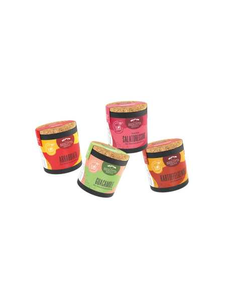 Vier Bio-Pappdosen in bunter Anordnung mit gelb-rotem, grünem, rosa-rotem und orange-rotem Etikett.