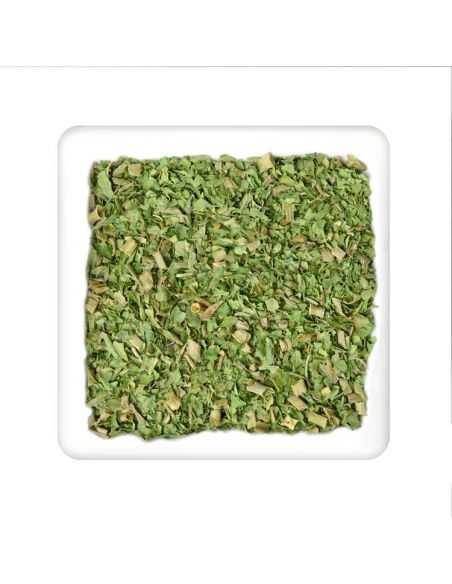 Quadratischer Teller mit grüner, grob geschnittener Kräutermischung