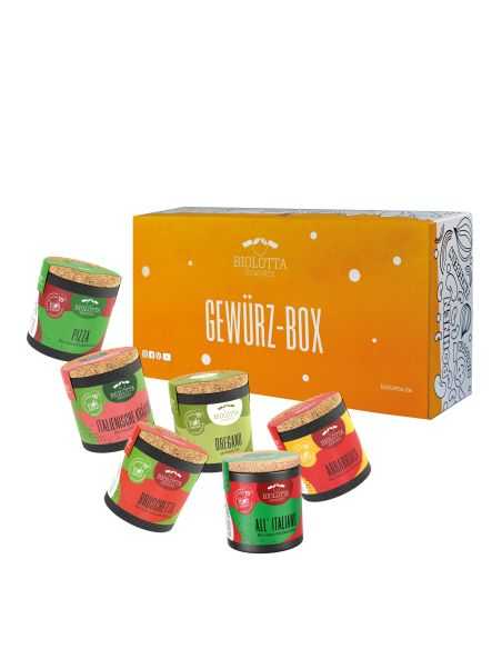 Sechs bunte Bio-Pappdosen vor einer orangefarbenen Geschenkbox mit der Aufschrift „Gewürz-Box