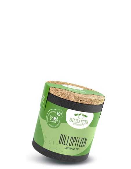 Grüne Pappdose mit schwarzem Boden, Korkdeckel und der Aufschrift „Dillspitzen, gerebelt, bio“ leicht schräg stehend.