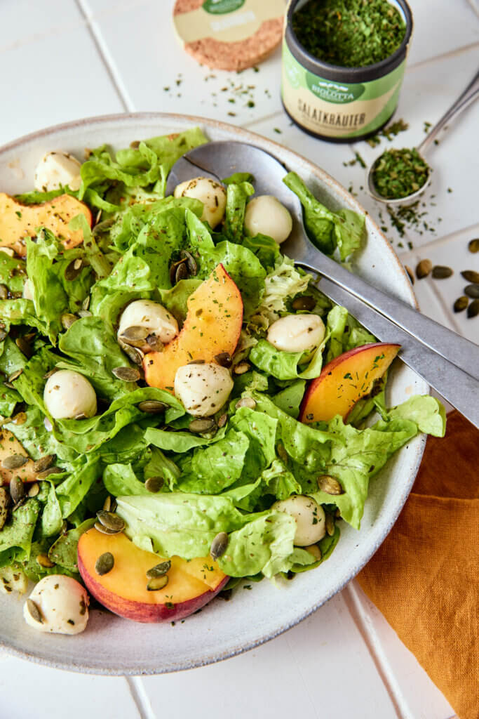 Sommersalat mit saftigen Pfirsichen und cremigem Mozzarella, verfeinert mit BioLotta Gewürzen – ideal für warme Tage.