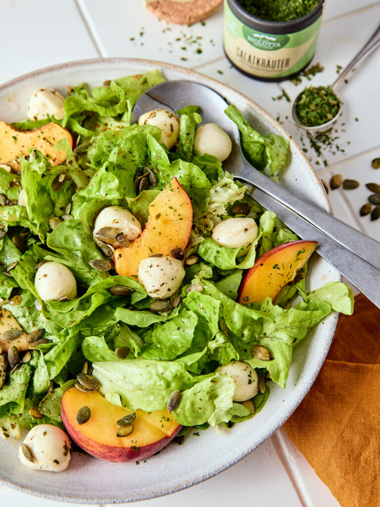 Sommersalat mit saftigen Pfirsichen und cremigem Mozzarella, verfeinert mit BioLotta Gewürzen – ideal für warme Tage.