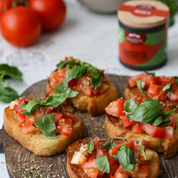 Sommerliche Bruschetta auf knusprigem Baguette mit saftigen Tomaten, frischem Basilikum und Knoblauch – eine leckere Vorspeise, zubereitet mit BioLotta Gewürzen.