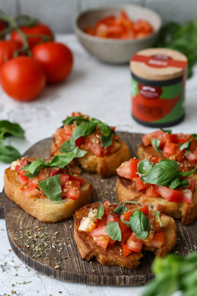 Sommerliche Bruschetta auf knusprigem Baguette mit saftigen Tomaten, frischem Basilikum und Knoblauch – eine leckere Vorspeise, zubereitet mit BioLotta Gewürzen.