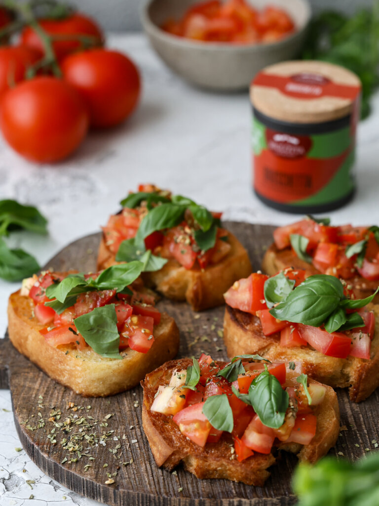 Sommerliche Bruschetta auf knusprigem Baguette mit saftigen Tomaten, frischem Basilikum und Knoblauch – eine leckere Vorspeise, zubereitet mit BioLotta Gewürzen.