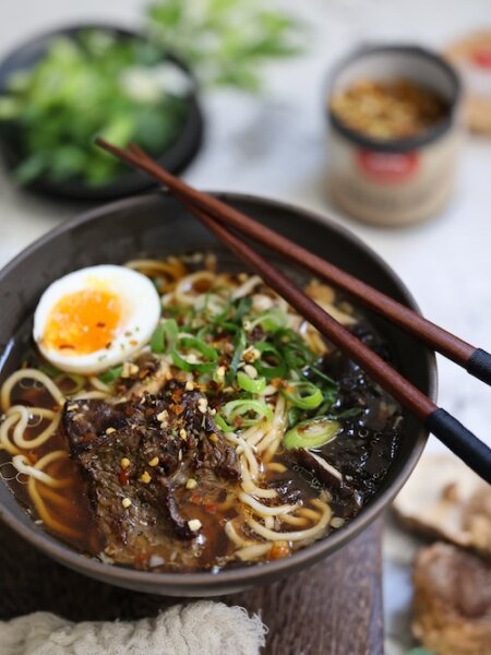 Miso-Ramen mit Rindfleisch, verfeinert mit BioLotta Knoblauch-Chili-Gewürz, serviert mit Ei, Shiitake und Nori in einer aromatischen Brühe.