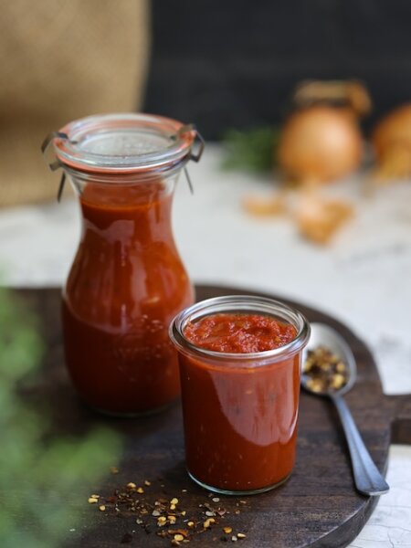 Feurige BBQ-Soße, abgeschmeckt mit BioLotta Chili-Mix und Paprikapulver, sämig eingekocht und in Gläser abgefüllt – ideal für Grillgerichte.