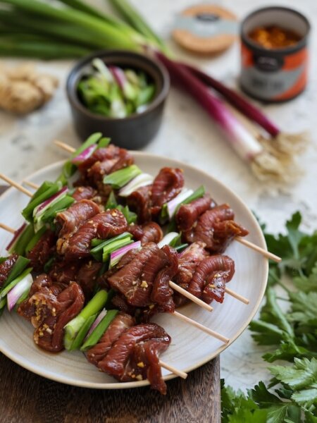 Teriyaki-Rindfleisch-Spieße mit Frühlingszwiebeln, bestreut mit Sesam und mariniert mit BioLotta Smoky BBQ Rub.