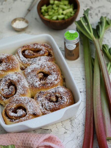 Zimtschnecken mit fruchtiger Rhabarberfüllung und BioLotta Zimt Cassia, goldbraun gebacken und mit Puderzucker bestäubt.