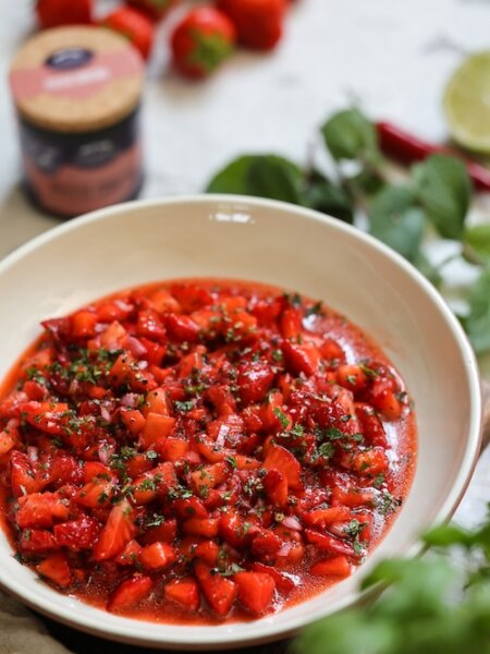 Fruchtige Erdbeer-Salsa mit Chili, Limette und frischen Kräutern in einer hellen Schüssel, serviert mit geröstetem Brot.