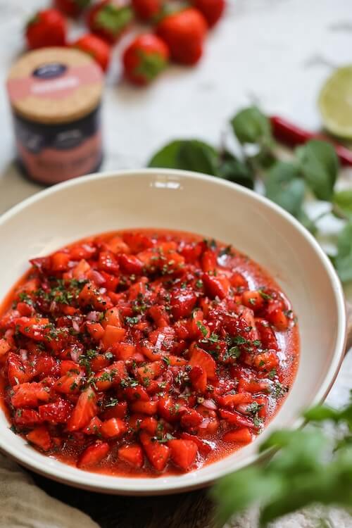 Fruchtige Erdbeer-Salsa mit Chili, Limette und frischen Kräutern in einer hellen Schüssel, serviert mit geröstetem Brot.
